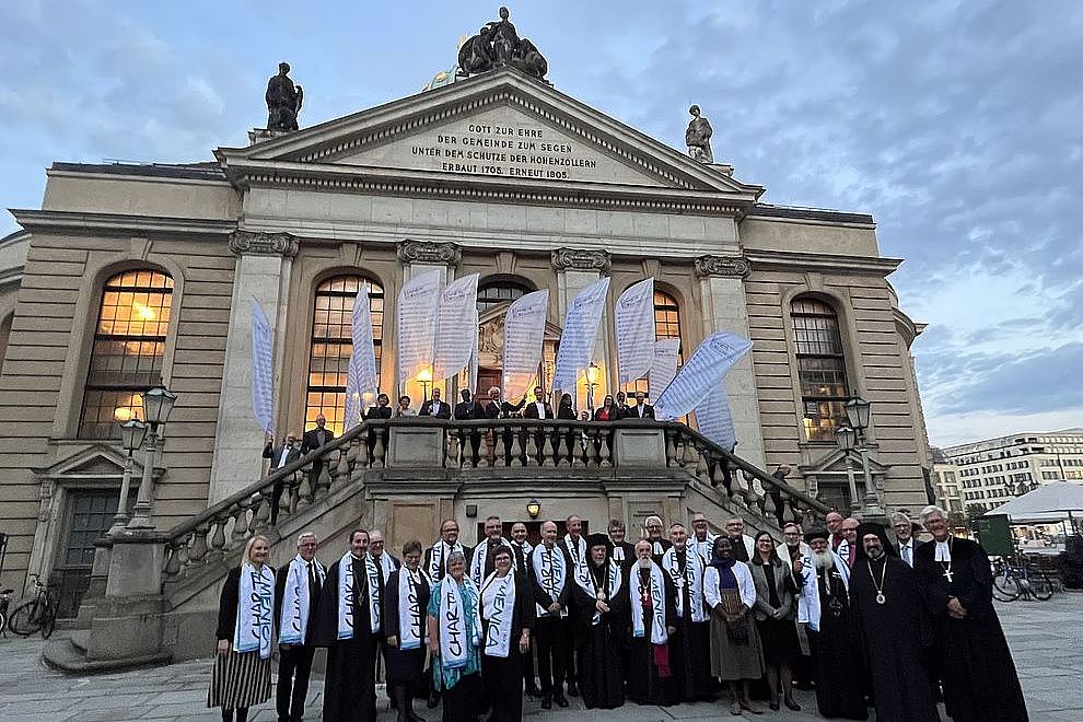 Menschen vor und mit Fahnen auf den Stufen zum Französischen Dom in Berlin
